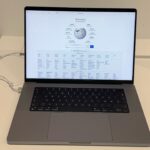 Current-design 16-inch Apple MacBook Pro with notch display, open on a store table