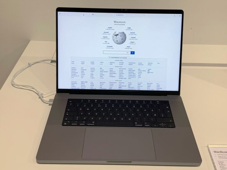 Current-design 16-inch Apple MacBook Pro with notch display, open on a store table