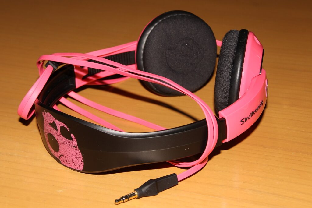 Pink and black Skullcandy headphones on a wooden table