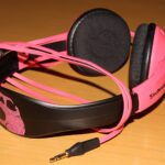 Pink and black Skullcandy headphones on a wooden table