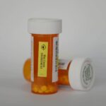 Orange prescription pill bottles with white caps, the kind of unused medication accepted on Drug Take Back Day