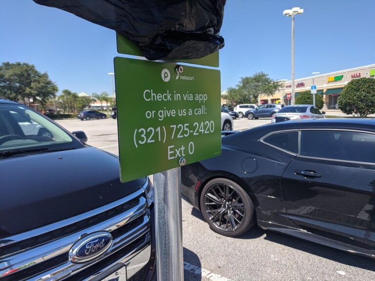 Green Publix and Instacart pickup parking sign in a grocery store parking lot
